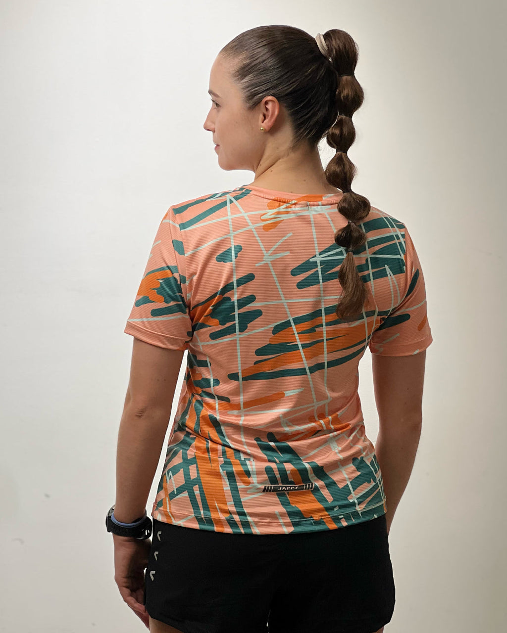 Corredora con Jersey Running graffiti coral para mujer, vista trasera completa