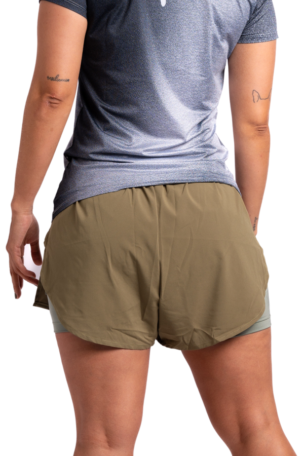 Imagen trasera Pantaloneta de running racer verde mujer color verde con licra interna, múltiples bolsillos, cintura anatómica.