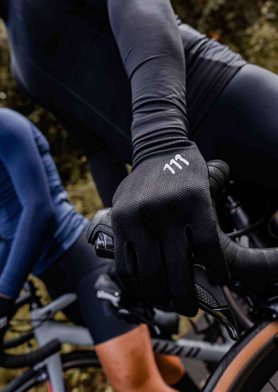 Foto de ciclista portanto guantes dedo largo negros.