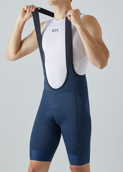 Modelo con pantaloneta de ciclismo azul oscura, marca Givelo. Detalle estirando tirantas