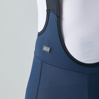 Modelo con pantaloneta de ciclismo azul oscura, marca Givelo. Detalle logo marca en costado de prenda.